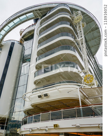 High back of a large cruise ship with balconies on a sky background, ship hull washing facility 118916052