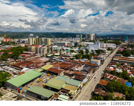 City landscape with modern building and small houses. Blue sky and clouds. Cagayan de Oro. Mindanao, Philippines. City landscape with modern building and small houses. Blue sky and clouds. Cagayan de Oro. Mindanao, Philippines. 118916272