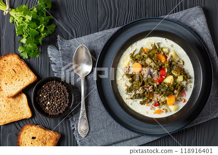 ground beef veggies kale soup in black bowl 118916401