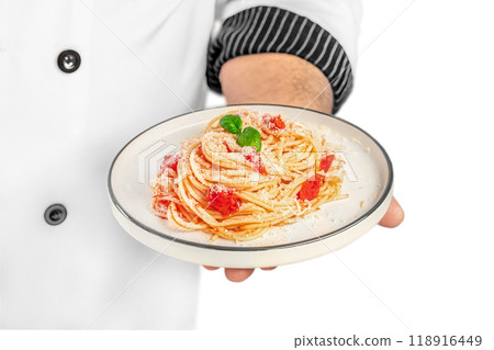 professional chef holding plate with tasty pasta Dish with tomato sauce and basil isolated on white background professional chef holding plate with tasty pasta Dish with tomato sauce and basil isolated on white background 118916449