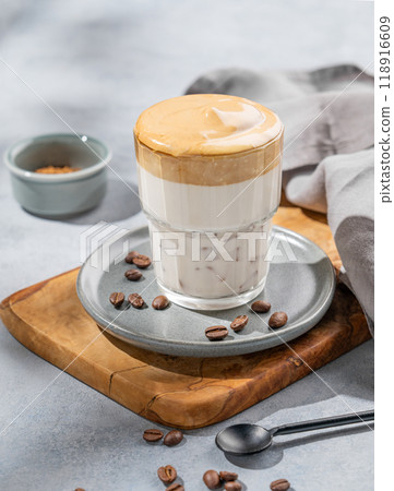 Dalgona coffee. Whipped instant coffee in a glass on a wooden board  with coffee beans  118916609