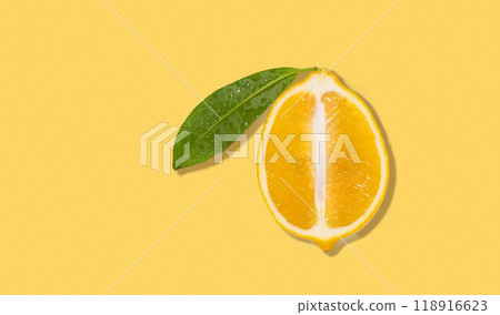 Fresh and juicy half of a lemon with leaf on a yellow isolated background with shadow. Fresh and juicy half of a lemon with leaf on a yellow isolated background with shadow. 118916623