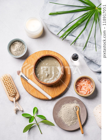 Organic cosmetic with blue clay, sea salt, brush, candle and palm leaf on a light background. Organic cosmetic with blue clay, sea salt, brush, candle and palm leaf on a light background. 118917051