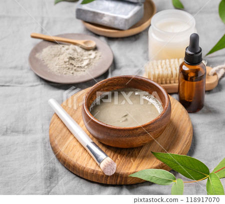 Organic cosmetic with blue clay, soap, brush, serum and candle on a linen background. Organic cosmetic with blue clay, soap, brush, serum and candle on a linen background. 118917070