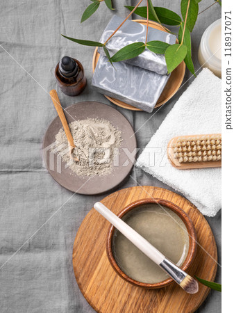 Organic cosmetic with blue clay, soap, brush, serum and towel on a linen background. Organic cosmetic with blue clay, soap, brush, serum and towel on a linen background. 118917071