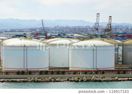Many large round white reservoirs of chemical products in the port industrial terminal tank farm Many large round white reservoirs of chemical products in the port industrial terminal tank farm 118917183