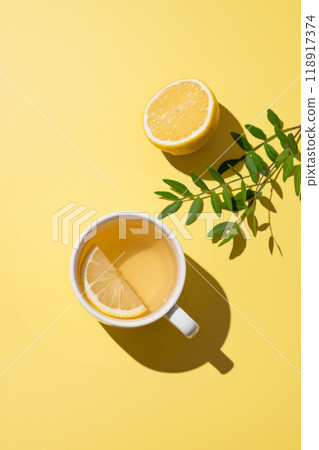 Herbal tea with lemon in a white cup on a yellow background. Detox drink concept for immunity. 118917374