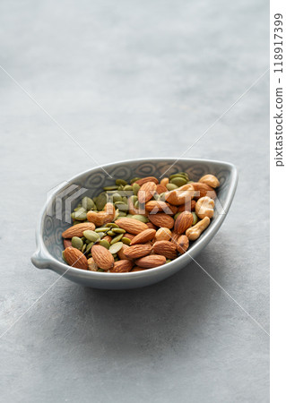 Mix of nuts. Almonds, cashews and pumpkin seeds in a bowl on a gray background. Mix of nuts. Almonds, cashews and pumpkin seeds in a bowl on a gray background. 118917399