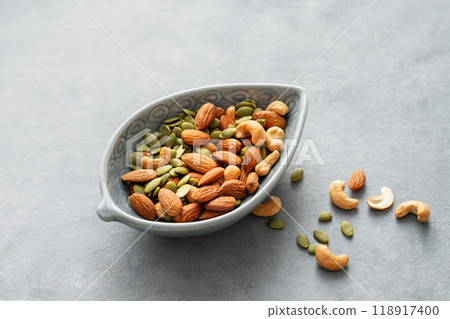 Mix of nuts. Almonds, cashews and pumpkin seeds in a bowl on a gray background. Mix of nuts. Almonds, cashews and pumpkin seeds in a bowl on a gray background. 118917400