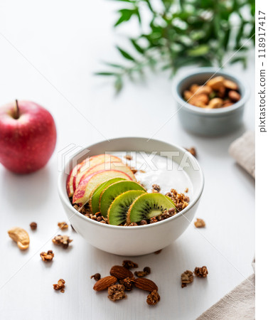 Healthy breakfast. Homemade granola or muesli with apple, kiwi and nuts in a bowl  118917417
