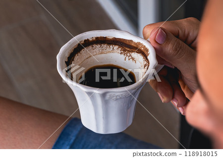 Enjoying a warm cup of dark coffee while relaxing at home Enjoying a warm cup of dark coffee while relaxing at home 118918015