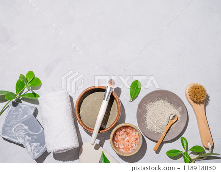 Organic blue clay, sea salt, soap, brush and towel on a light background with shadow. Organic blue clay, sea salt, soap, brush and towel on a light background with shadow. 118918030