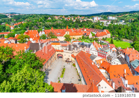 The courtyard of Cesky Krumlov Castle showcases vibrant red roofs and lush greenery, highlighting the unique architecture and serene atmosphere of this historic Czech location. The courtyard of Cesky Krumlov Castle showcases vibrant red roofs and lush greenery, highlighting the unique architecture and serene atmosphere of this historic Czech location. 118918078