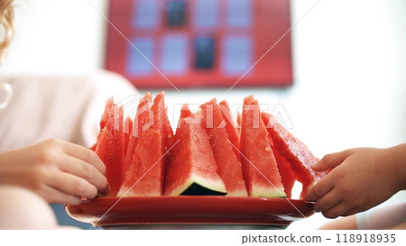 Two kids eat juicy red watermelon slices at home Two kids eat juicy red watermelon slices at home 118918935