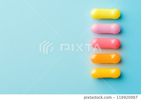Colorful gummy candies arranged vertically on a blue background displaying a vibrant assortment of flavors and hues 118920987