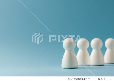 White figurines lined up against a blue background during a minimalistic display of unity and teamwork White figurines lined up against a blue background during a minimalistic display of unity and teamwork 118921009