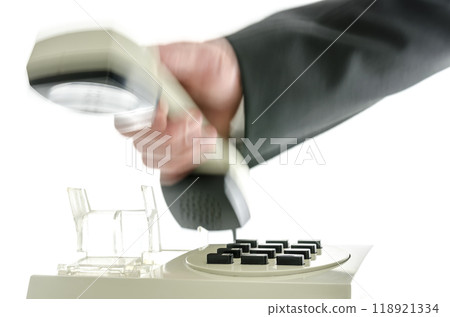 Blurred hand hanging up telephone receiver 118921334