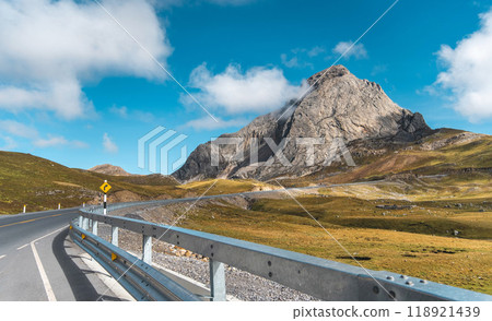 A mountain range is visible in the distance behind a road. rock megalithic. Huayllay Stone Forest, Peru. 118921439