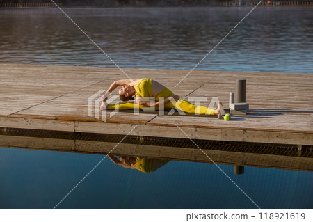 Experience a Serene Outdoor Yoga Practice by the Water, embracing peace and tranquility 118921619