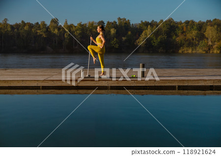 Morning Yoga by the Tranquil Water A Perfect Blend of Fitness and Inner Serenity Morning Yoga by the Tranquil Water A Perfect Blend of Fitness and Inner Serenity 118921624
