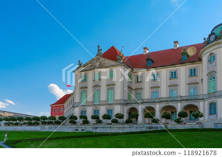 A stunning old palace with a red roof surrounded by beautiful gardens. 118921678