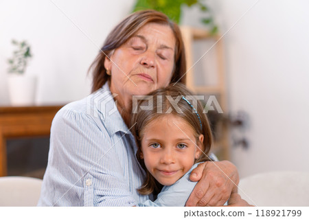 Loving grandmother embracing cute granddaughter Loving grandmother embracing cute granddaughter 118921799
