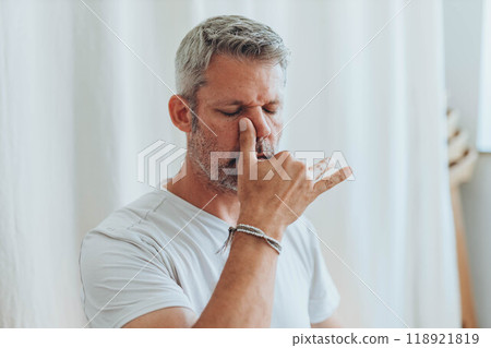 A man practicing alternate nostril breathing exercises during a meditation session A man practicing alternate nostril breathing exercises during a meditation session 118921819