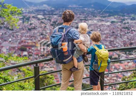 Dad and her two sons, a baby and a teenager tourists in front of the panoramic view of Orizaba from Cerro del Borrego, Mexico. Travel, scenic landscape, and adventure concept Dad and her two sons, a baby and a teenager tourists in front of the panoramic view of Orizaba from Cerro del Borrego, Mexico. Travel, scenic landscape, and adventure concept 118921852