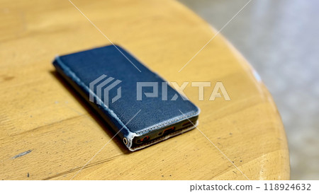 Smartphone with an old cover placed on a table Smartphone with an old cover placed on a table 118924632