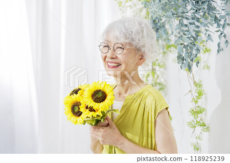 Senior woman holding sunflowers Senior woman holding sunflowers 118925239