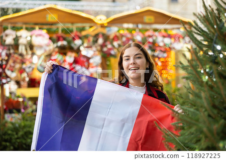 Cheerful girl with flag of France at Christmas city market Cheerful girl with flag of France at Christmas city market 118927225