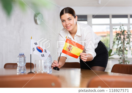 Businesswoman arranging the flags of South Korea and Spain for presentation and negotiations 118927571