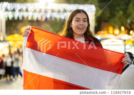 Happy girl with Austrian flag waving at New Year fair 118927658