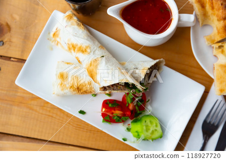 Delicious lula-kebab in lavash with vegetables and herbs Delicious lula-kebab in lavash with vegetables and herbs 118927720