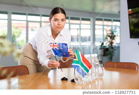 Preparing for business presentation - secretary places flags of Australia and South Africa on negotiating table Preparing for business presentation - secretary places flags of Australia and South Africa on negotiating table 118927751