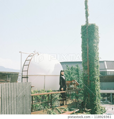 安裝在建築物屋頂上的球形物體和穿著黑色裙子的女人 118928361