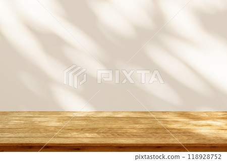 Empty wood table top on beige wall texture with tree leaves shadow background Empty wood table top on beige wall texture with tree leaves shadow background 118928752