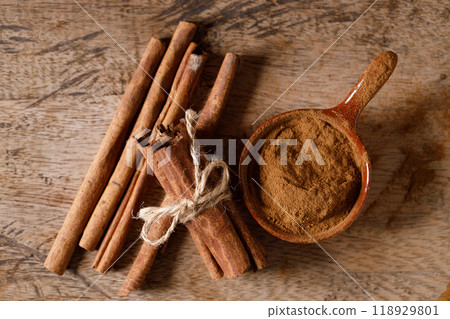 Aromatic cinnamon sticks and powder on wooden table. 118929801