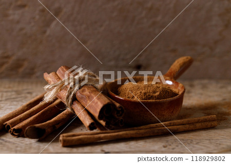Aromatic cinnamon sticks and powder on wooden table. 118929802
