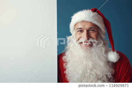 Santa Claus in festive red costume presenting blank banner for custom holiday message, blue background, ideal for Christmas promotions or advertisement 118929871