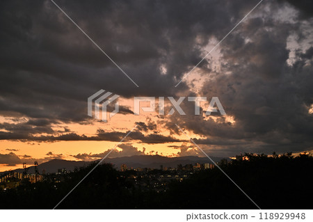 傍晚時分，城市的燈光開始閃耀，烏雲遮住了天空 118929948