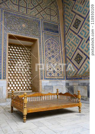 Traditional Asian carved wooden cot in Ulugbek Madrasah of the 14th century in Samarkand, Uzbekistan 118930109