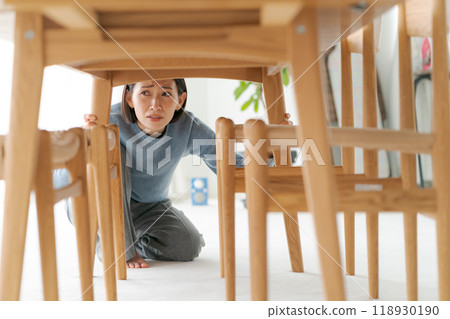一個女人躲在桌子下面 118930190