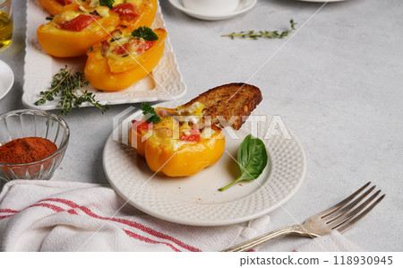 Variation of healthy breakfast with eggs baked in yellow pepper with cream cheese, ham and tomato on the plate with braed, on gray background. Food concept. copy space Variation of healthy breakfast with eggs baked in yellow pepper with cream cheese, ham and tomato on the plate with braed, on gray background. Food concept. copy space 118930945