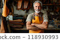Portrait of a smiling senior artisan at leather workshop, copy space 118930993