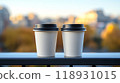 Two paper cups with Coffee take away on the on the railing against the backdrop of the autumn city copy space 118931015