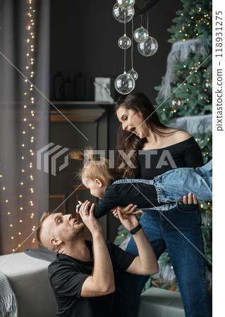Joyful family playing together near Christmas tree Joyful family playing together near Christmas tree 118931275