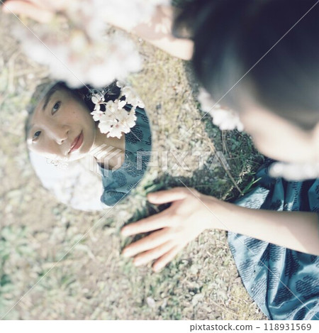 Cherry blossoms and a woman's face reflected in a mirror Cherry blossoms and a woman's face reflected in a mirror 118931569
