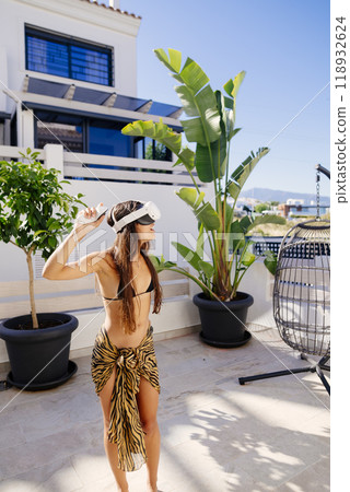 Tropical Vibes A Beautiful Woman in a Stylish Beach Outfit Surrounded by Lush, Vibrant Plants Tropical Vibes A Beautiful Woman in a Stylish Beach Outfit Surrounded by Lush, Vibrant Plants 118932624