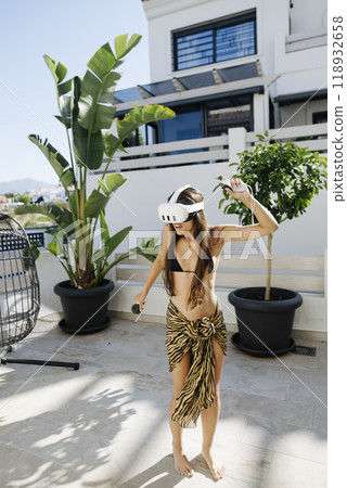 A Young Woman Is Enjoying a Virtual Reality Experience While Outdoors in Natures Beauty 118932658